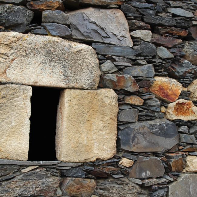 Pared de piedra con una pequeña ventana