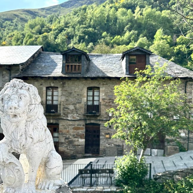 Casa de piedra y escultura de un león