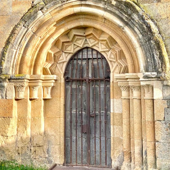 Puerta de madera con arcos de piedra